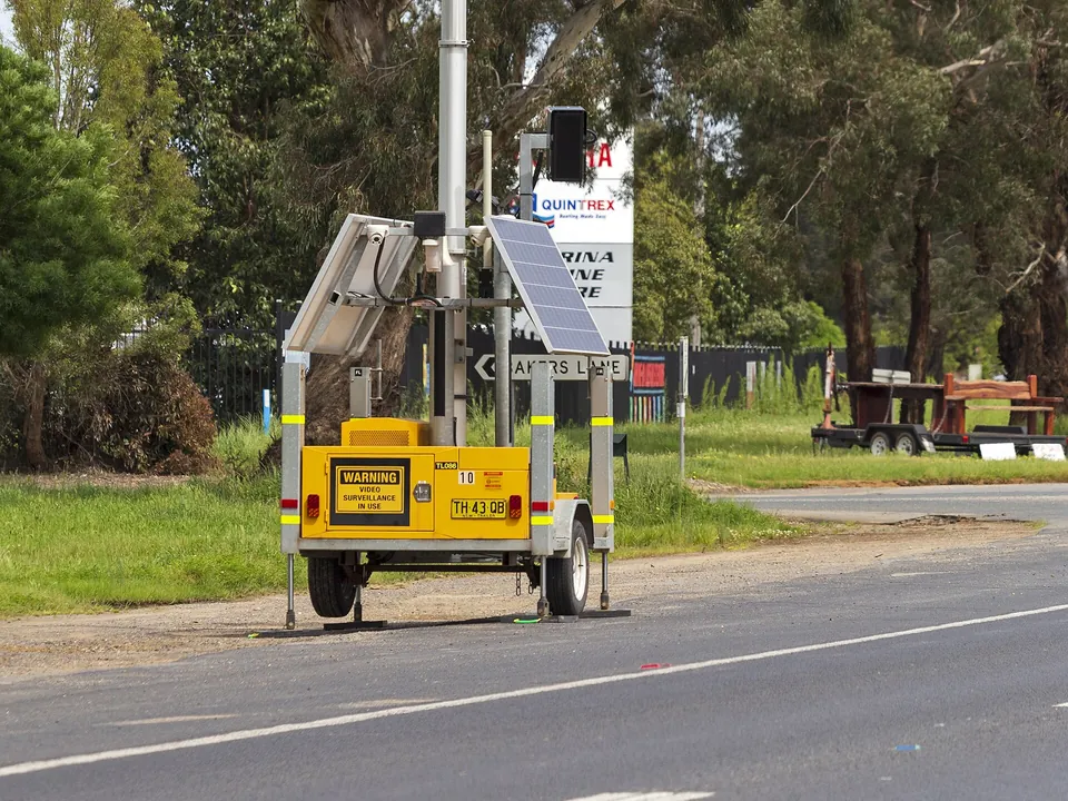 A trailer-mounted mobile phone detection camera beside a highway