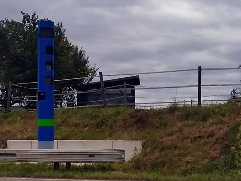 A tall blue toll enforcement column beside a main road