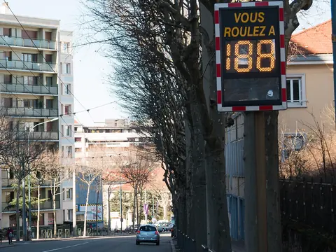 An electronic sign on a pole showing a passing driver's speed