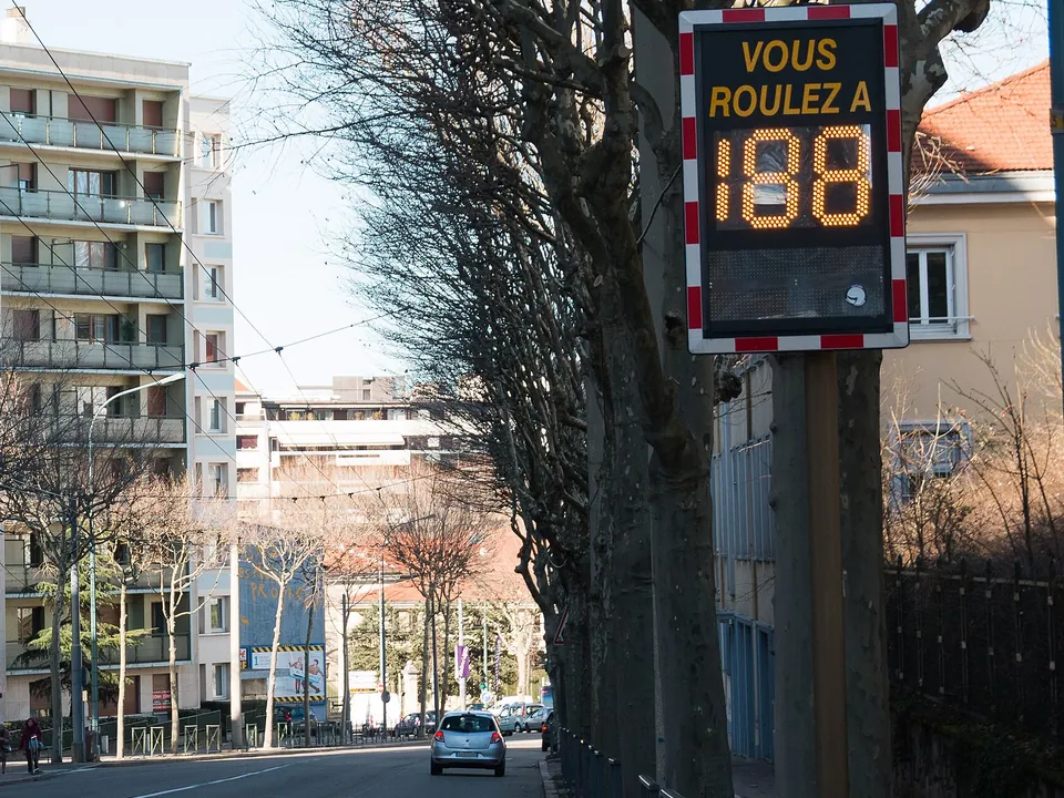 An electronic sign on a pole showing a passing driver's speed