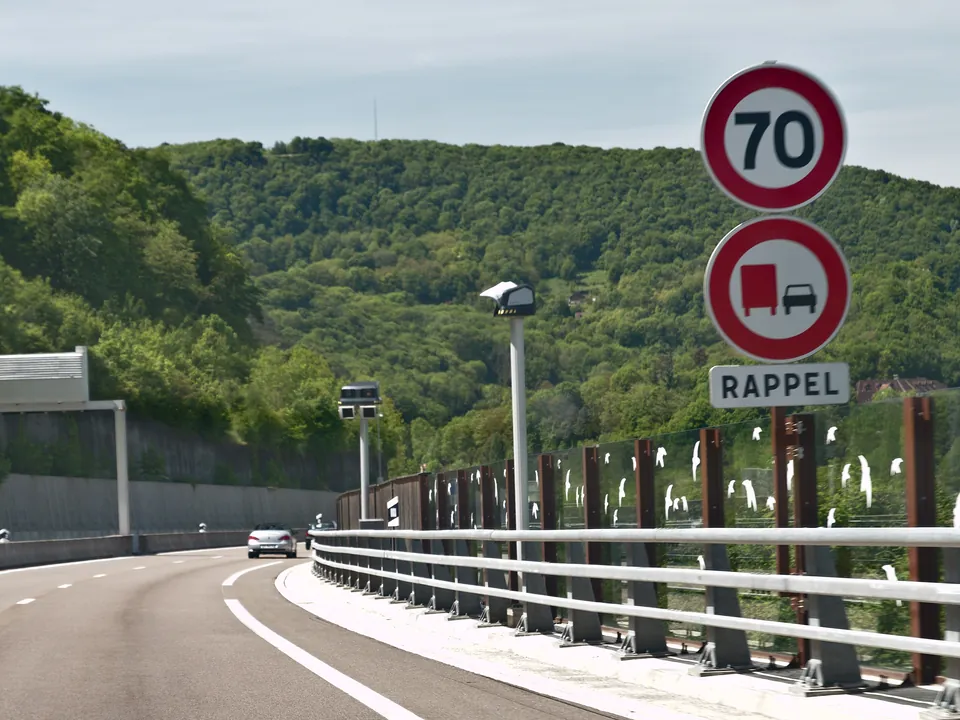 Average speed cameras on a pole beside a dual carriageway, below 70 km/h signs