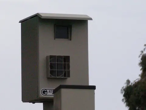 A speed camera housing on a tall post