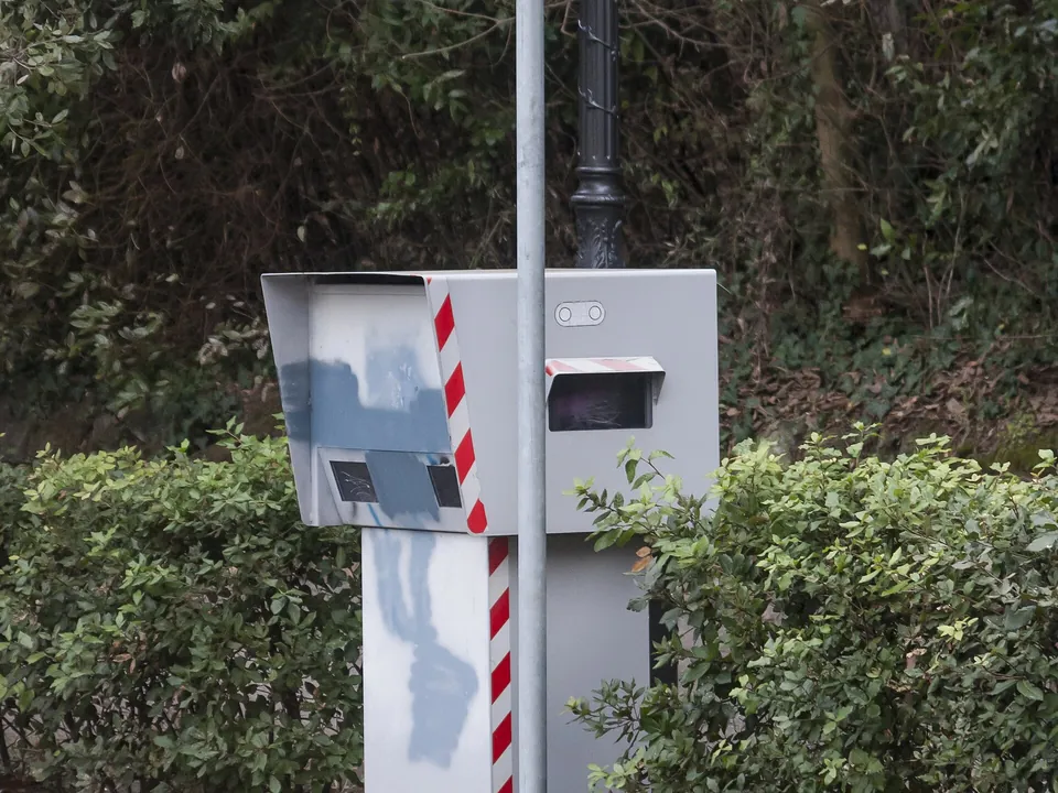 A fixed speed camera box under a sign saying postazione fissa misuratore della velocità